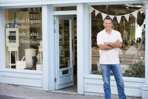 Man standing in front of organic food store smiling